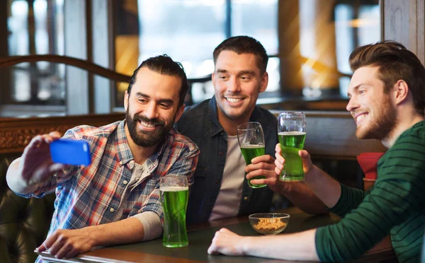 Amis prenant selfie avec de la bière verte au pub — Photo