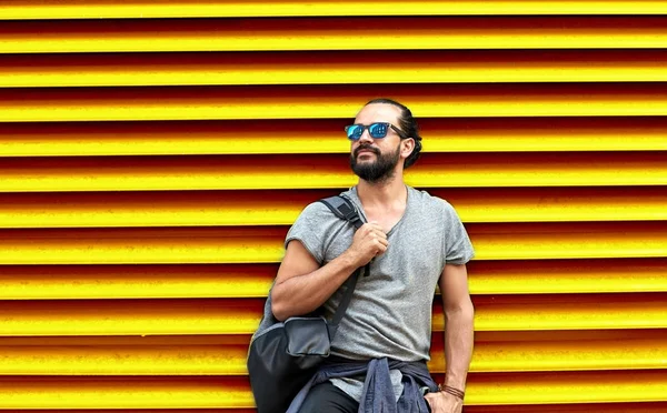 Człowiek w okulary z stojący torba na street wall — Zdjęcie stockowe