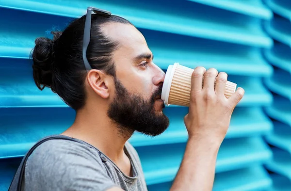 Mann trinkt Kaffee aus Pappbecher über Wand — Stockfoto