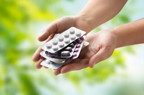 Woman hands holding packs of pills — Stock Photo, Image