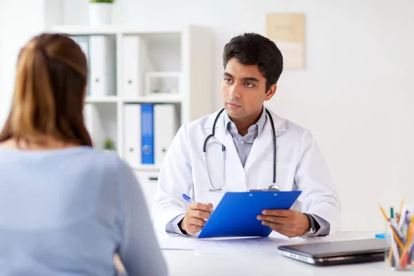 Arzt mit Klemmbrett und Patient im Krankenhaus — Stockfoto