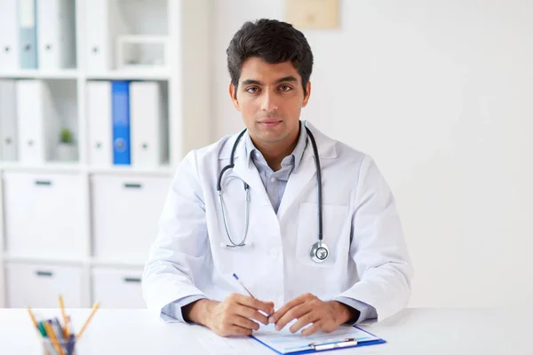 Médecin avec stéthoscope et presse-papiers à la clinique — Photo