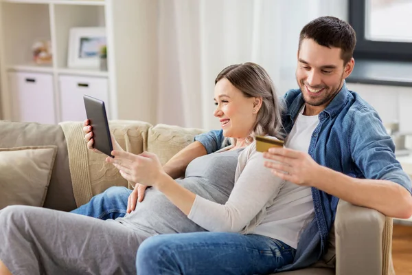 Hombre y esposa embarazada de compras en línea en casa — Foto de Stock