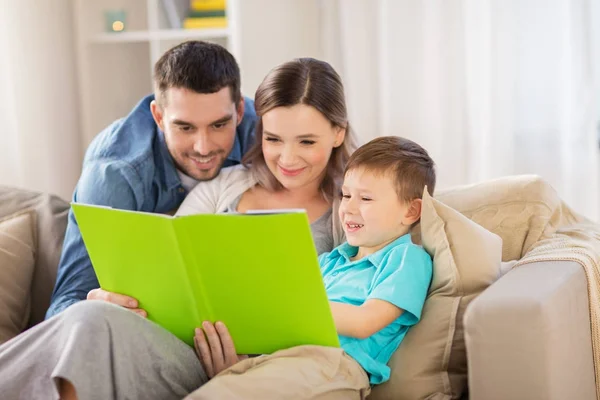 Happy family reading book at home — Stock Photo, Image