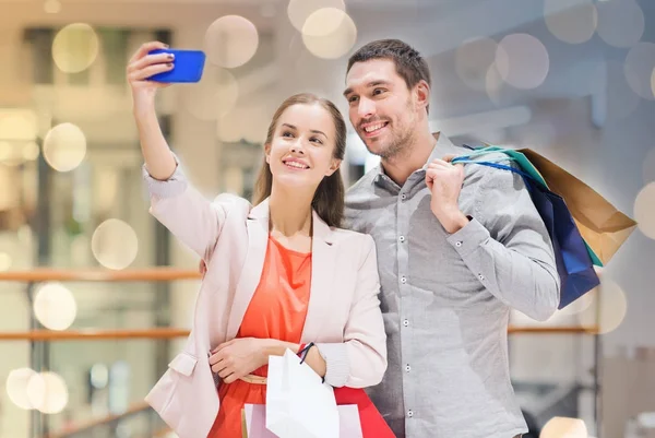 Щаслива пара зі смартфоном, що приймає селфі в торговому центрі — стокове фото