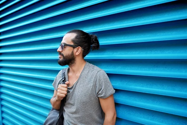 Uomo in occhiali da sole con borsa in piedi al muro della strada — Foto Stock
