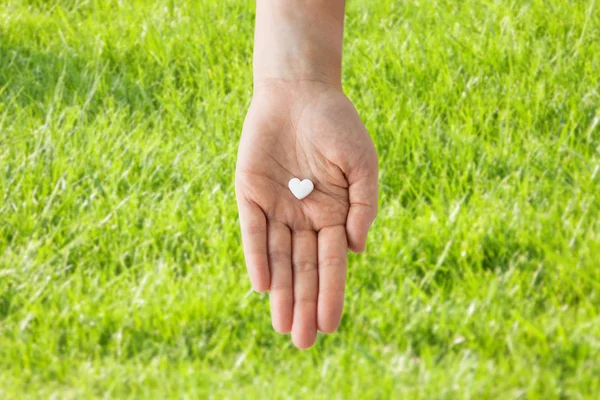 Zavřít z ruky držící medicína pilulka srdce — Stock fotografie