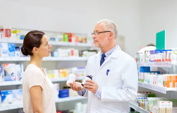 Speziale e donna con farmaco in farmacia — Foto Stock