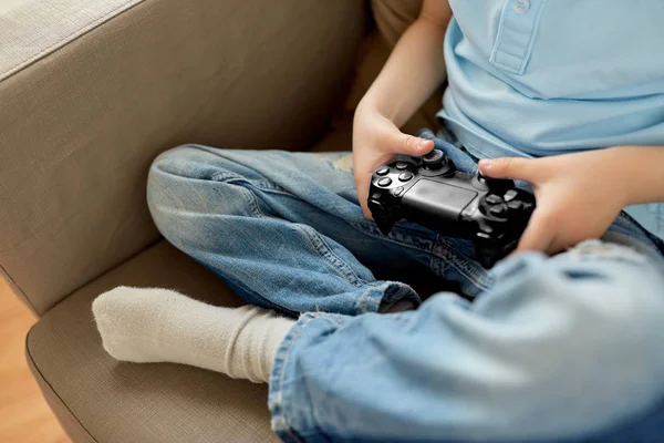 Liten pojke med gamepad spelar TV-spel hemma — Stockfoto