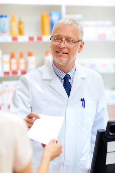 Vedoucí lékárník s předpisem v lékárně — Stock fotografie