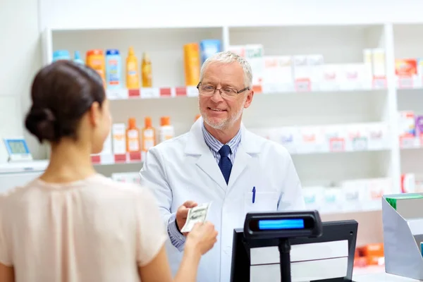 Zákazník dává peníze na lékárníkem v lékárně — Stock fotografie