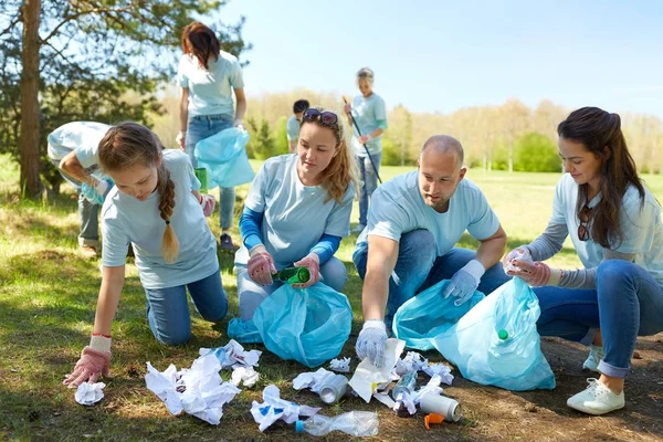 Bénévoles avec sacs à ordures nettoyage de la zone du parc — Photo