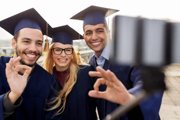 Estudantes ou graduados tirando selfie por smartphone — Fotografia de Stock
