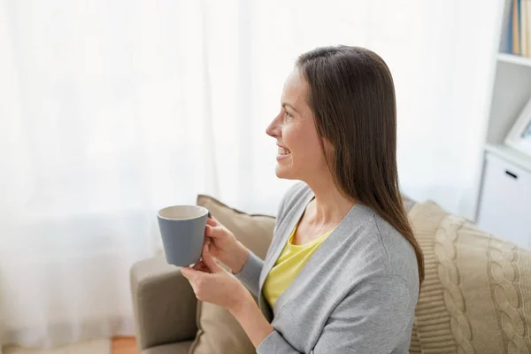 家でお茶やコーヒーを飲む幸せな女 — ストック写真