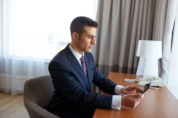 Businessman with tablet pc working at hotel room — Stock Photo, Image