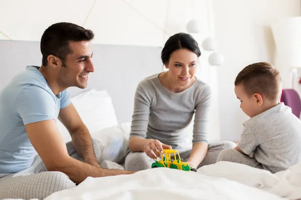 Szczęśliwa rodzina w łóżku w domu lub pokoju hotelowym — Zdjęcie stockowe