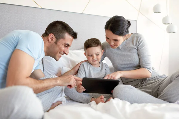 幸福的家庭，与平板电脑在家里的床上 — 图库照片