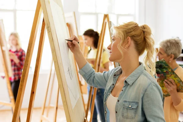 Woman with easel drawing at art school studio — Stock Photo, Image