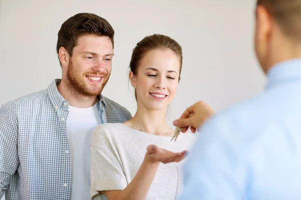 Agente de bienes raíces dando llaves de nuevo hogar a la pareja feliz — Foto de Stock