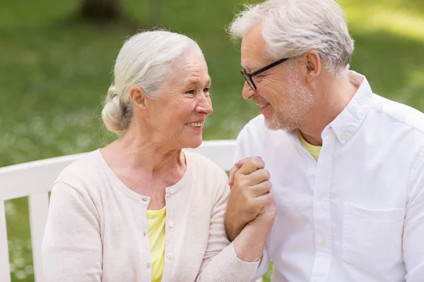 Glückliches Seniorenpaar sitzt auf Bank im Park — Stockfoto