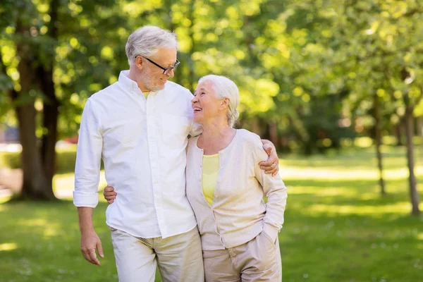 Счастливая пожилая пара обнимается в летнем парке — стоковое фото