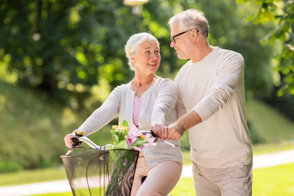 Felice coppia anziana con bicicletta al parco estivo — Foto Stock