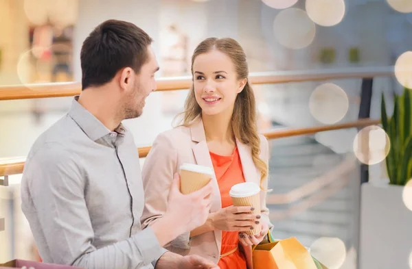 Casal feliz com sacos de compras beber café — Fotografia de Stock