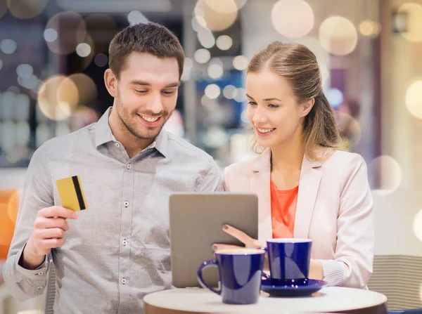 Pareja con tablet pc y tarjeta de crédito en el centro comercial — Foto de Stock