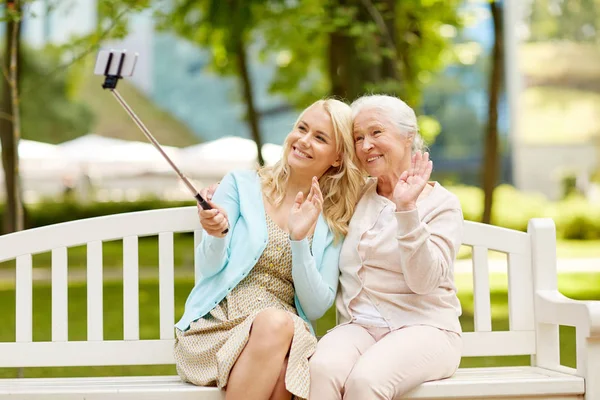 Figlia e madre anziana scattare selfie al parco — Foto Stock