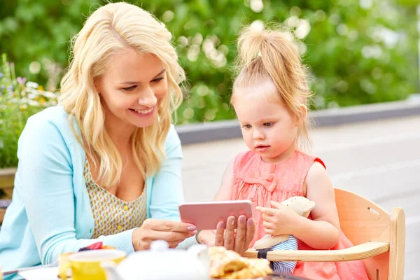 Mor och dotter med smartphone på café — Stockfoto