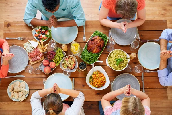 Grupa ludzi w tabeli modlitwa przed posiłkiem — Zdjęcie stockowe