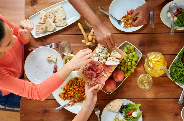 Bir grup insan gıda ile masada yemek — Stok fotoğraf
