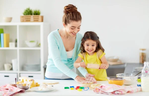 Feliz madre e hija haciendo galletas en casa —  Fotos de Stock