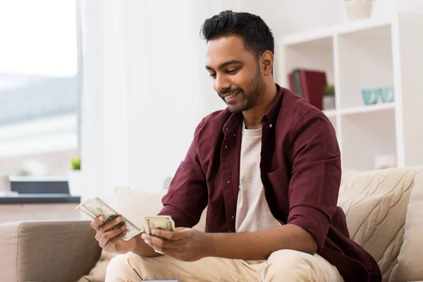 Sonriente hombre contando dinero en casa — Foto de Stock