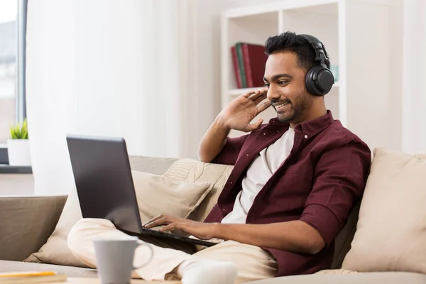 Fejhallgató-val laptop zenét hallgat az ember — Stock Fotó