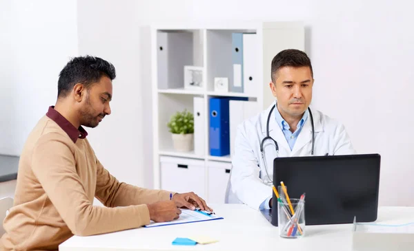 Лікар з ноутбуком і пацієнткою чоловічої статі в лікарні — стокове фото