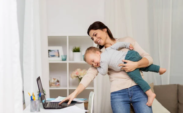 Щаслива мати з дитиною і ноутбуком працює вдома — стокове фото