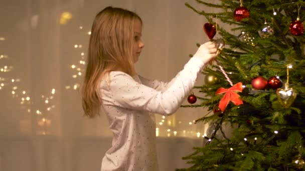 Glad flicka dekorera julgran hemma — Stockvideo