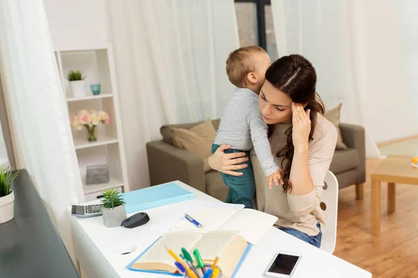 Mère étudiante avec bébé apprenant à la maison — Photo