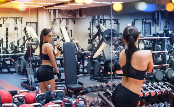 Frau mit Smartphone macht Spiegel-Selfie im Fitnessstudio — Stockfoto