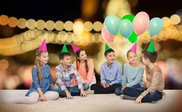 Feliz sonriente niños en partido sombreros en cumpleaños —  Fotos de Stock