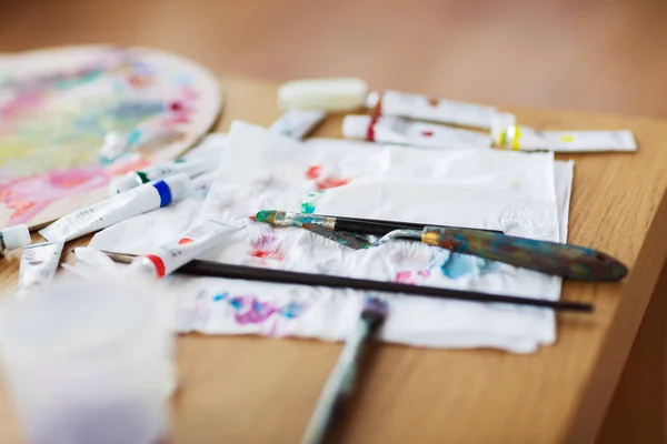 Palette knife, brushes and paint on paper tissue — Stock Photo, Image