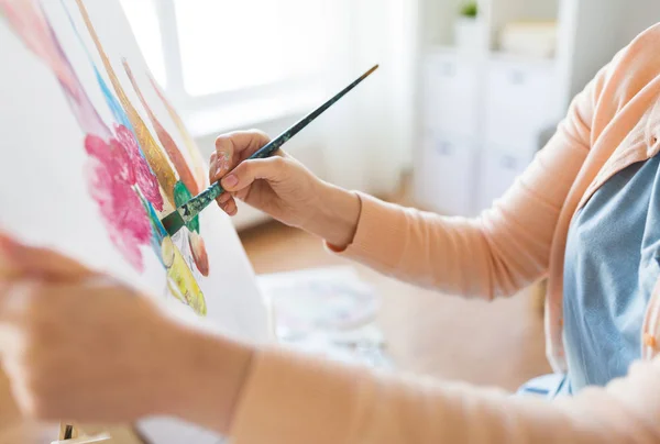 Artista con pincel pintura naturaleza muerta en el estudio — Foto de Stock