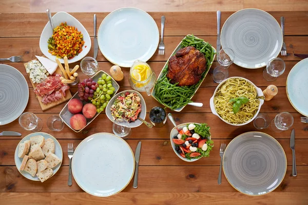 Vários alimentos na mesa de madeira servida — Fotografia de Stock