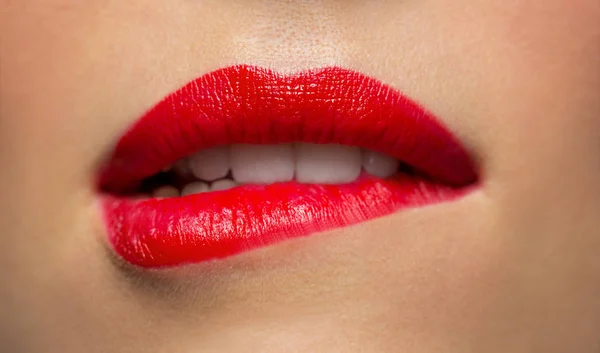 Close up of woman with red lipstick biting lip — Stock Photo, Image