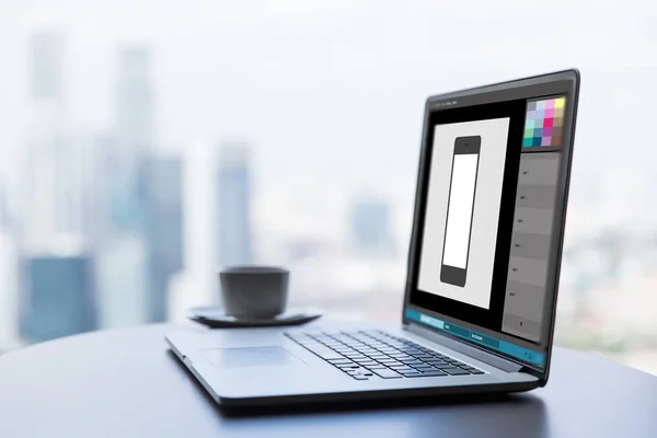 Laptop med smartphone bild i grafik redaktör — Stockfoto