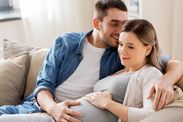 Homme étreignant femme enceinte à la maison — Photo