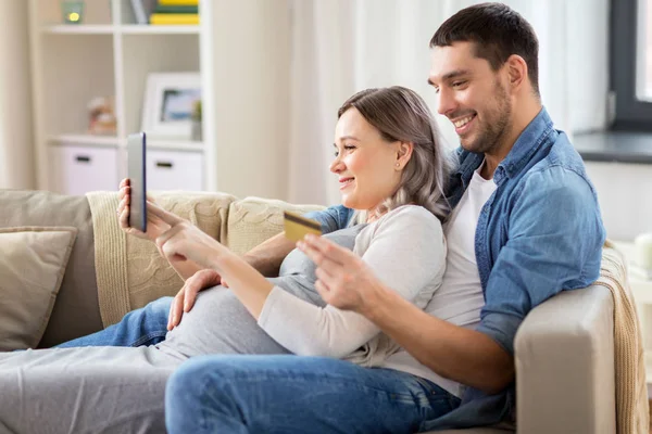 Man en zwangere vrouw thuis online winkelen — Stockfoto