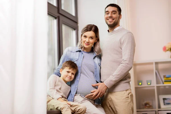 Keluarga bahagia dengan ibu hamil di rumah — Stok Foto