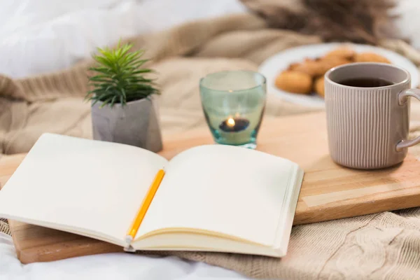 Dagbok, te och ljus i hållare hemma — Stockfoto